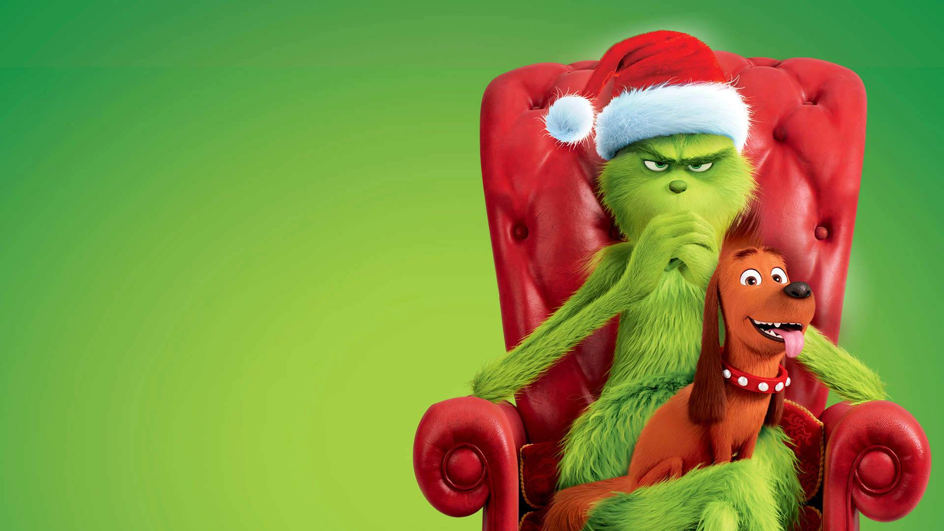 The Grinch sitting in a red chair wearing a Santa hat with a happy dog on his lap